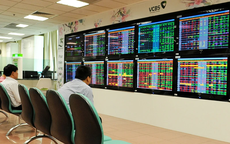 Khách hàng theo dõi bảng giao dịch chứng khoán tại sàn giao dịch Vietcombank (VCBS). Ảnh: PHẠM HƯNG