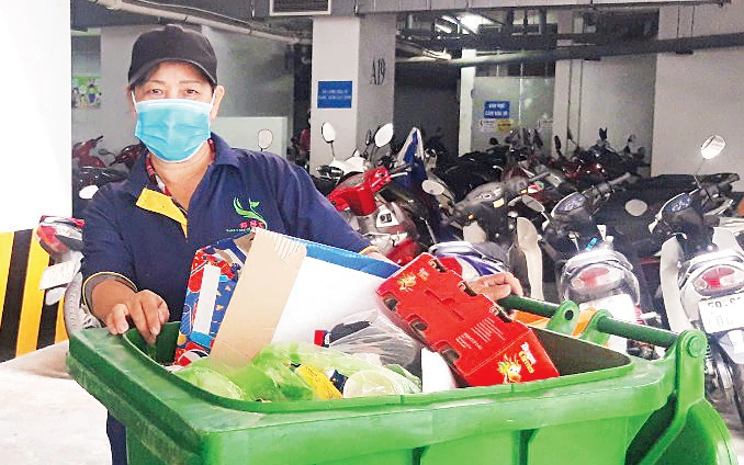TP Hồ Chí Minh đặt mục tiêu đến năm 2025 sẽ triển khai phân loại chất thải rắn sinh hoạt trên toàn thành phố. Trong ảnh: Thu gom rác tại một khu chung cư.