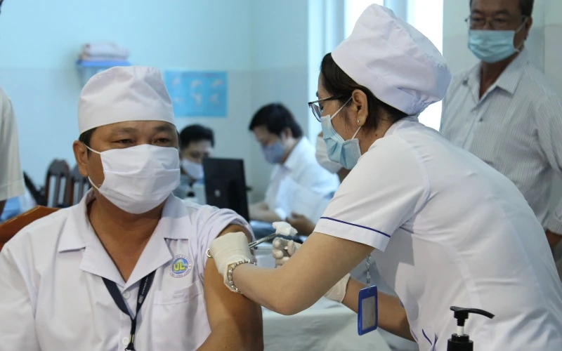 Điều dưỡng Nguyễn Văn Võ, Khoa kiểm soát nhiễm khuẩn thuộc đội phản ánh nhanh phòng, chống Covid-19 tại Bệnh viện đa khoa tỉnh Vĩnh Long được tiêm mũi đầu tiên.