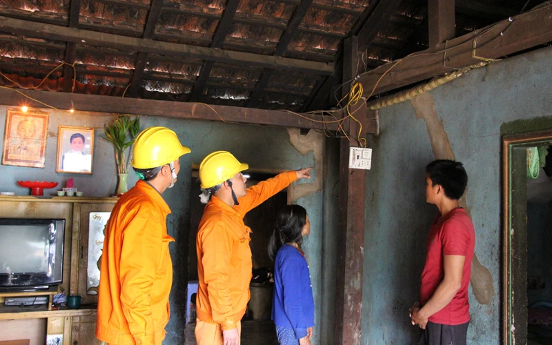 Công nhân Điện lực Ngọc Hồi (PC Kon Tum) sửa chữa, thay thế dây, bóng điện miễn phí cho các hộ nghèo tại vùng biên giới huyện Ngọc Hồi, tỉnh Kon Tum.