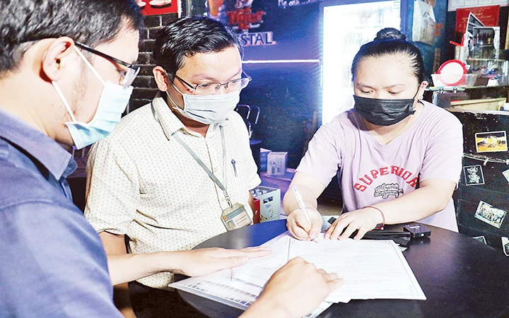 Đoàn kiểm tra quận Bình Thạnh ( TP. Hồ Chí Minh) tuyên truyền, yêu cầu cơ sở kinh doanh ký cam kết không vi phạm tiếng ồn. Ảnh | THÁI PHƯƠNG