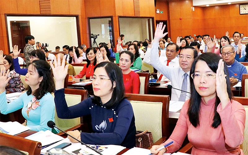 Các đại biểu HÐND thành phố Hồ Chí Minh khóa 9 biểu quyết thông qua Nghị quyết tại một kỳ họp.