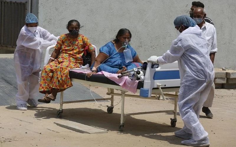 Nhân viên y tế chuyển người bệnh từ bệnh viện điều trị Covid-19 tại TP Ahmedabad, Ấn Độ, sang bệnh viện khác để nhường chỗ cho bệnh nhân mới. (Ảnh: AP)
