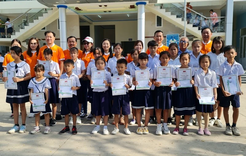 Đại diện Quỹ học bổng “Vì trẻ em đến trường” trao học bổng cho học sinh Trường tiểu học dân lập Cảnh Thành (tỉnh Sóc Trăng).