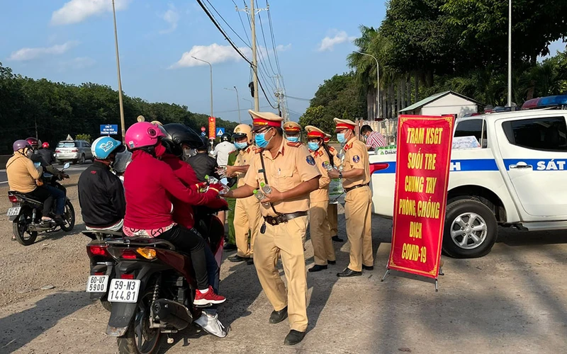 Lực lượng CSGT Công an tỉnh Đồng Nai phát nước suối cho người dân trên Quốc lộ 1A.