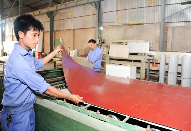Công nhân Công ty TNHH Tiến Lợi (Khu công nghiệp Lai Xá, Hoài Đức, Hà Nội) sản xuất tôn.