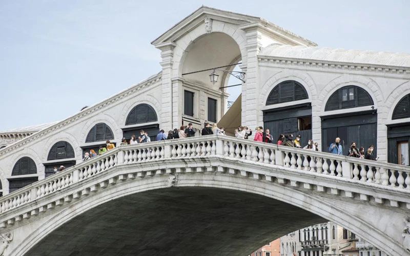 Du khách tới thăm cây cầu Rialto ở Venice, miền bắc Italy hôm 1-5. Italy đang dần mở cửa trở lại sau sáu tháng đóng cửa để ngăn chặn Covid-19. (Ảnh: AP)