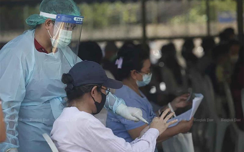 Nhân viên y tế đang hướng dẫn cho người dân đăng ký xét nghiệm tại quận Pathumwan, Thủ đô Bangkok, Thái Lan. (Ảnh: Bưu điện Bangkok)