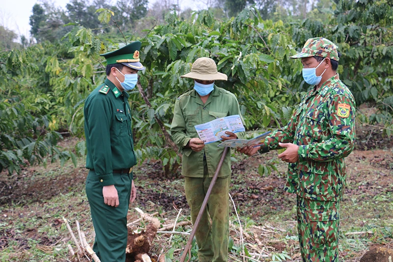 Cán bộ Đồn Biên phòng Cửa khẩu Thuận An, huyện Đắk Mil đến tận rẫy phát tài liệu, vận động người dân phòng, chống dịch Covid-19.