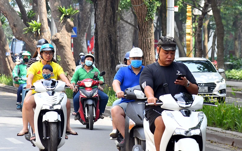 Nhiều người dân Hà Nội chưa chấp hành quy định đeo khẩu trang tại nơi công cộng. Ảnh: NAM NGUYỄN