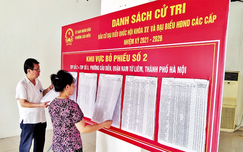 Người dân phường Cầu Diễn xem danh sách cử tri niêm yết tại khu vực bỏ phiếu số 2.