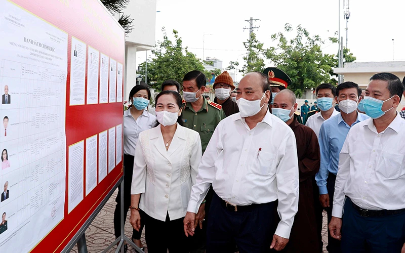 Chủ tịch nước Nguyễn Xuân Phúc xem danh sách các ứng cử viên đại biểu Quốc hội niêm yết tại xã Trung Chánh, huyện Hóc Môn. Ảnh: Thống Nhất (TTXVN)