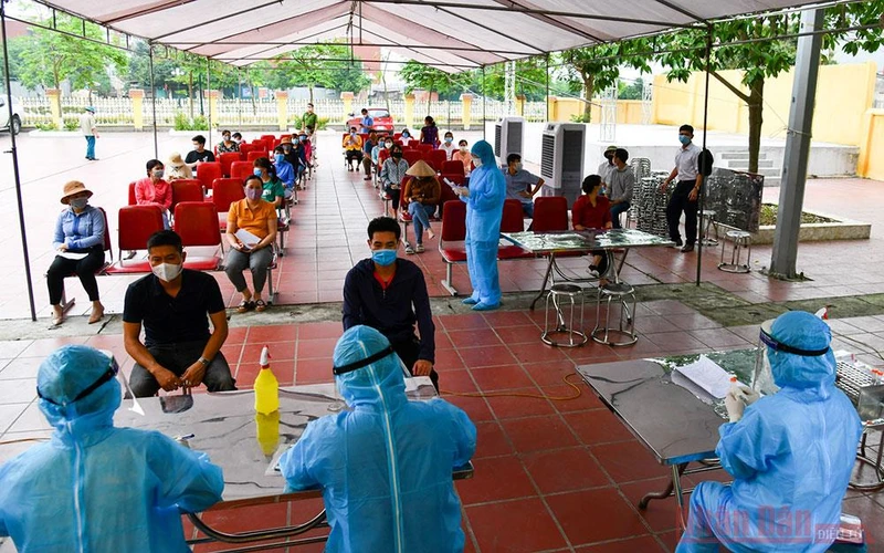 Lấy mẫu xét nghiệm cho người dân ở Kim Chung, Đông Anh, gần khu vực Bệnh viện Nhiệt đới Trung ương. Ảnh: DUY LINH