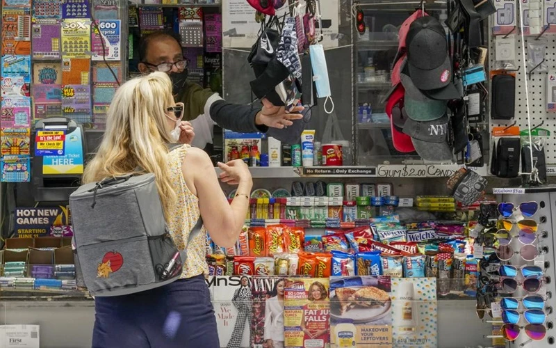Người phụ nữ mua khẩu trang trên đường phố New York, Mỹ. (Ảnh: AP)