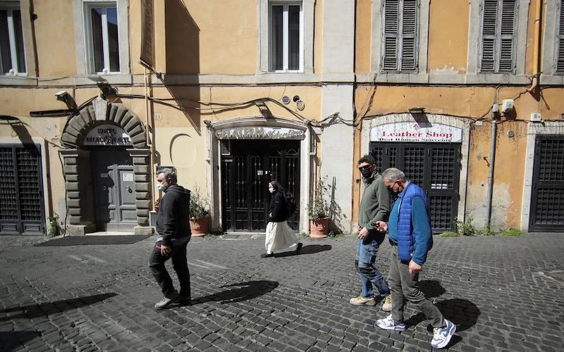 Ảnh minh họa: Người dân đeo khẩu trang đi bộ qua các cửa hàng đóng cửa tại Rome, Italy, ngày 30-3-2021, khi các lệnh hạn chế do Covid-19 ở vùng Lazio được nới lỏng. (Ảnh: Reuters)