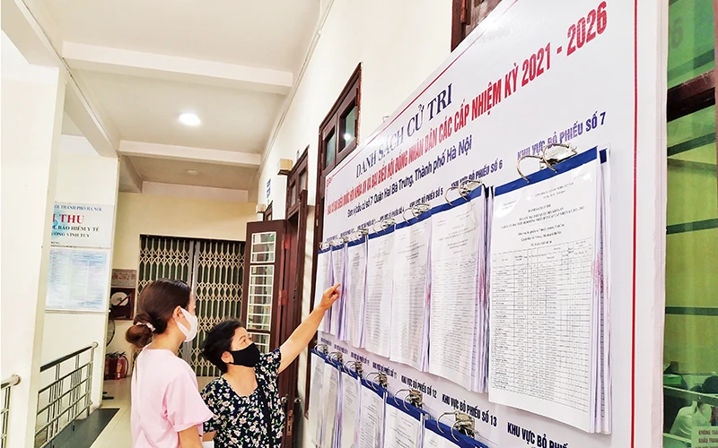 Người dân xem danh sách cử tri niêm yết tại trụ sở UBND phường Vĩnh Tuy (Hai Bà Trưng, Hà Nội).