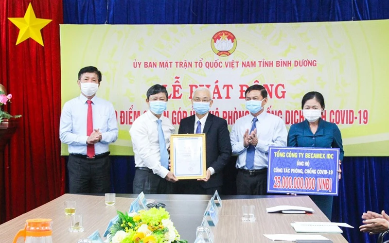 Phó Bí thư Thường trực Tỉnh ủy, Chủ tịch HĐND tỉnh Bình Dương Võ Văn Minh (thứ hai, từ trái sang) trao bảng tấm lòng vàng nhân đạo cho lãnh đạo Tổng Công ty Becamex IDC.