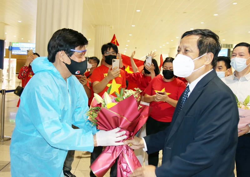 Trưởng đoàn ĐT Việt Nam Nguyễn Sỹ Hiển nhận hoa chúc mừng của Đại sứ đặc mệnh toàn quyền Việt Nam tại UAE Nguyễn Mạnh Tuấn. (Ảnh: VFF)