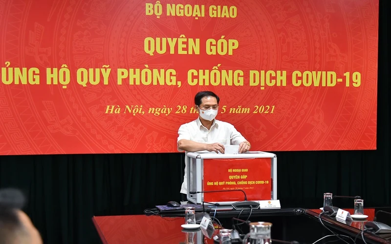 Bộ trưởng Ngoại giao Bùi Thanh Sơn quyên góp ủng hộ công tác phòng, chống dịch Covid-19. (Ảnh: Bộ Ngoại giao)