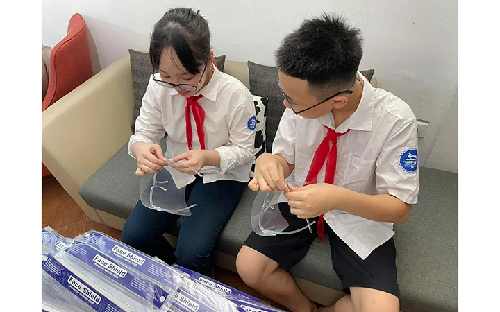 Thiếu nhi quận Hoàn Kiếm hào hứng tự tay làm từng tấm chắn giọt bắn dành tặng các bác sĩ nơi tuyến đầu chống dịch Covid-19 (ảnh chụp trước ngày 29-4-2021).