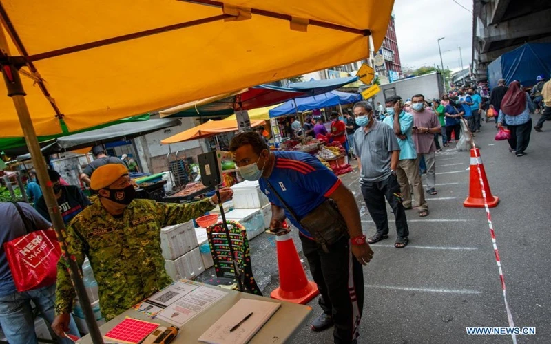 Người dân đeo khẩu trang xếp hàng vào một khu chợ trước khi lệnh phong tỏa có hiệu lực tại thủ đô Kuala Lumpur của Malaysia. (Ảnh: Tân Hoa xã)