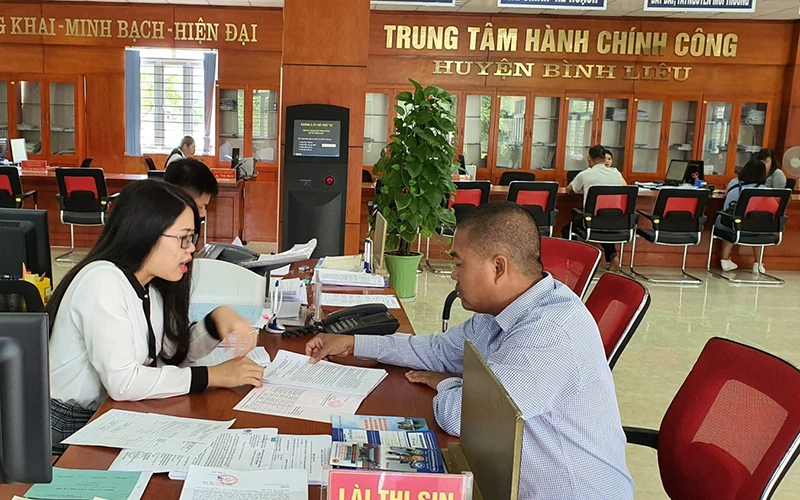 Cán bộ Trung tâm Hành chính công huyện Bình Liêu hướng dẫn người dân làm thủ tục.