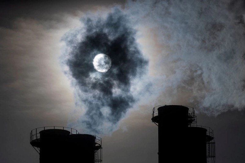 Mặt trời chiếu qua khí thải bốc lên từ ống khói một nhà máy điện ở Moscow, Nga. Ảnh: Reuters.