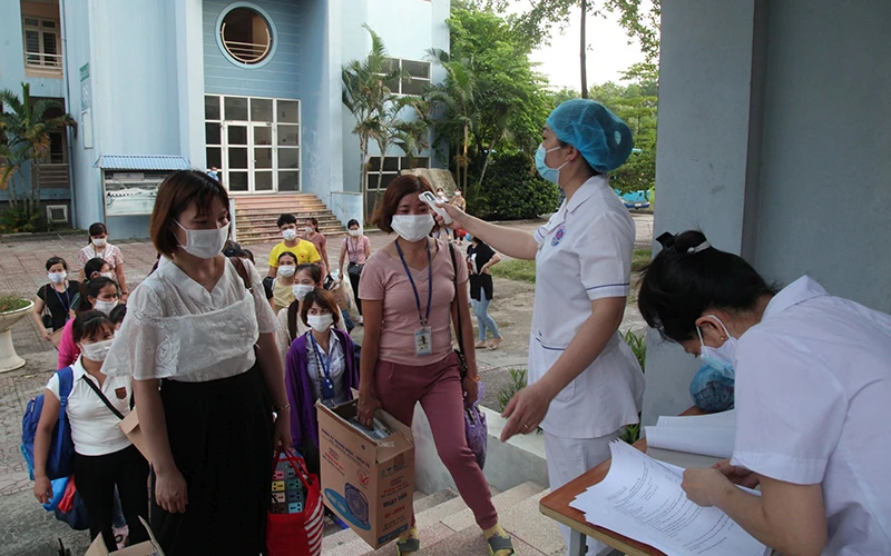 Công nhân kiểm tra thân nhiệt và khai báo y tế trước khi vào khu vực nhà ở tại Trường cao đẳng Công nghiệp và Thương mại (Vĩnh Phúc).