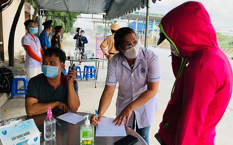 Lực lượng tại chốt kiểm soát Covid-19 quốc lộ 1K, hướng dẫn người dân khai báo y tế trước khi vào địa bàn tỉnh Đồng Nai.