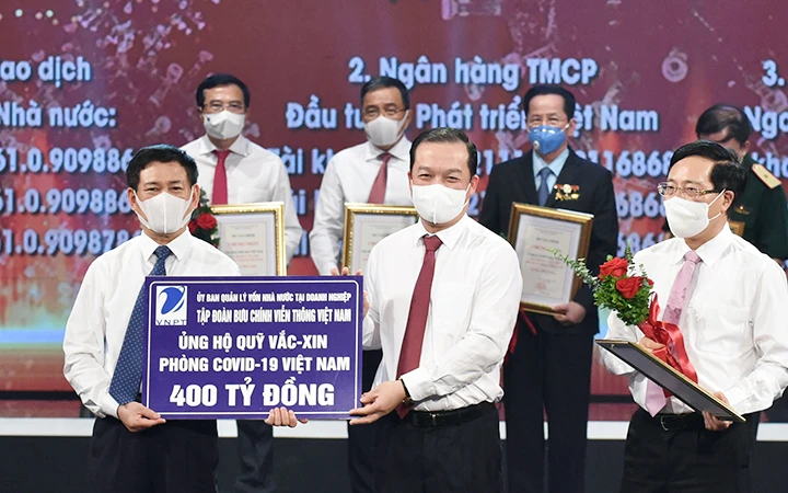 Chủ tịch HĐTV Tập đoàn VNPT Phạm Đức Long trao số tiền 400 tỷ đồng ủng hộ Quỹ vắc-xin phòng, chống Covid-19. Ảnh: AN AN