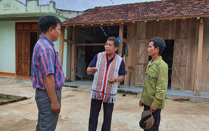 Già làng A Blong (giữa) tuyên truyền chủ trương, chính sách của Nhà nước đến với người dân. 