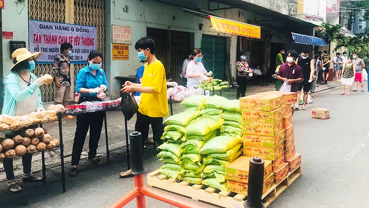 Người dân nhận nhu yếu phẩm từ gian hàng 0 đồng trên địa bàn phường Tân Thành, quận Tân Phú.