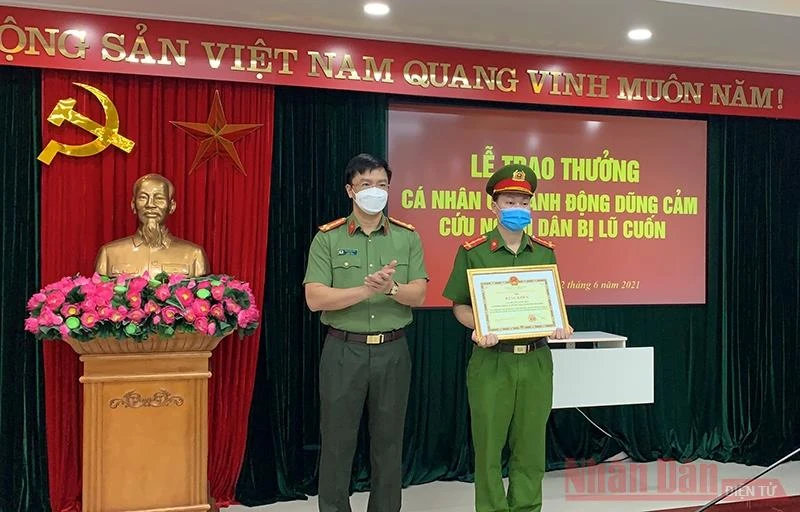 Đại tá Phạm Kim Đĩnh, Giám đốc Công an tỉnh Tuyên Quang trao bằng khen của Chủ tịch UBND tỉnh cho Đại úy Hoàng Ngọc Hào.