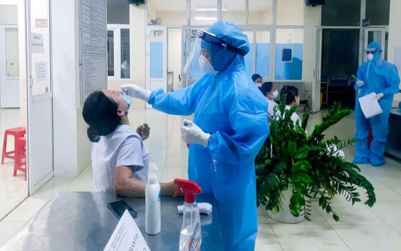 Cán bộ CDC Nghệ An lấy mẫu xét nghiệm cán bộ y tế phường Hà Huy Tập. Ảnh: THÀNH CHÂU