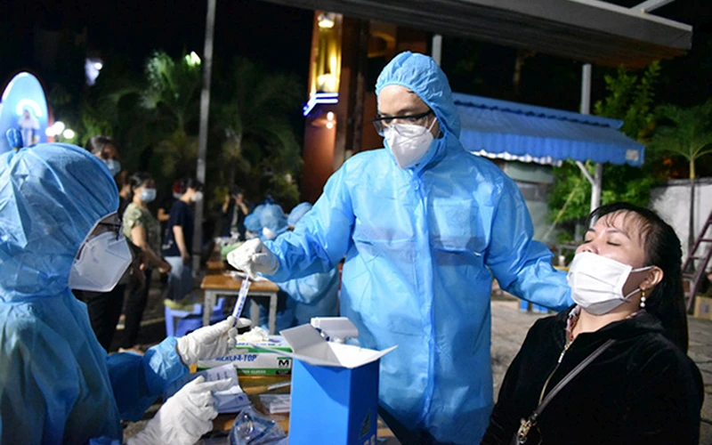 Nhân viên y tế lấy mẫu xét nghiệm cho người dân sống ở khu vực có nguy cơ cao tại quận Gò Vấp (TP Hồ Chí Minh).