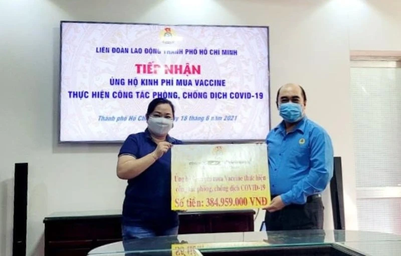 Công đoàn Đại học Quốc gia TP Hồ Chí Minh trao bảng biểu trưng kinh phí mua vaccine Covid-19 cho Liên đoàn Lao động TP Hồ Chí Minh.