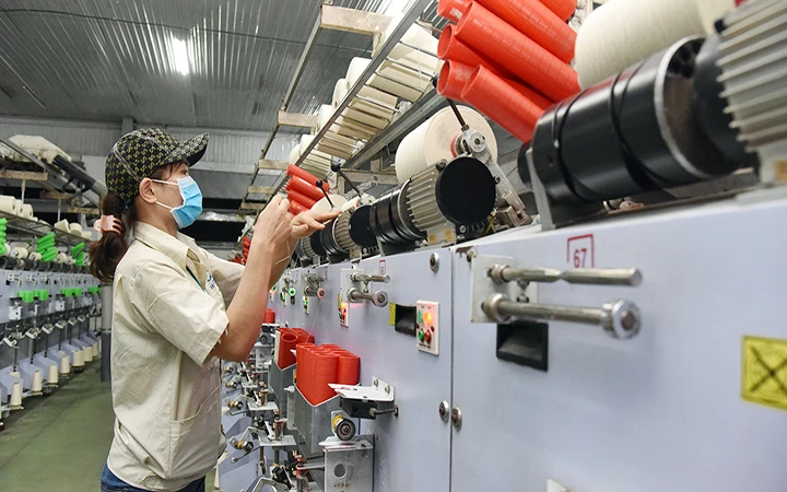 Công nhân Công ty TNHH dệt Hà Nam (Khu công nghiệp Châu Sơn, Hà Nam) vận hành dây chuyền sản xuất sợi. Ảnh: TRẦN LÂM