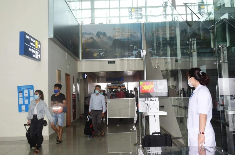 Nhân viên y tế và máy tự động kiểm tra thân nhiệt hành khách về Cảng hàng không Thọ Xuân