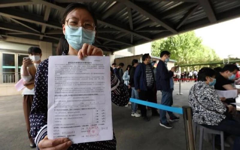 Một người dân Trung Quốc với giấy đăng ký mũi tiêm vaccine ngừa Covid-19 thứ nhất.