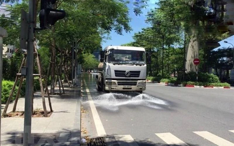 Công ty TNHH MTV Môi trường Đô thị Hà Nội, Chi nhánh Đống Đa thực hiện tưới nước làm mát, giảm bụi tại tuyến đường Hoàng Cầu (Đống Đa) trong những ngày nắng nóng. (Ảnh: TTXVN)