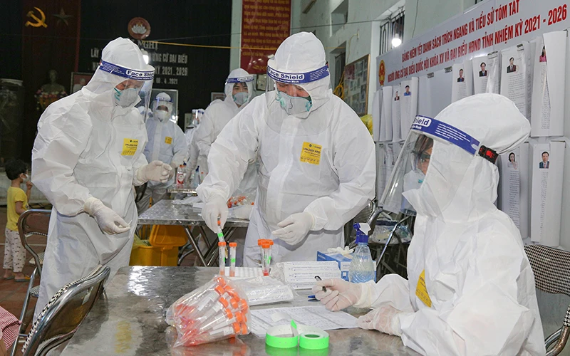 Các y sĩ, bác sĩ Bệnh viện Quân y 110 (Cục Hậu cần Quân khu 1) lấy mẫu xét nghiệm SARS-CoV-2 đối với người dân xã Mão Điền, huyện Thuận Thành (Bắc Ninh) - nơi được coi là ổ dịch có nhiều ca nhiễm.