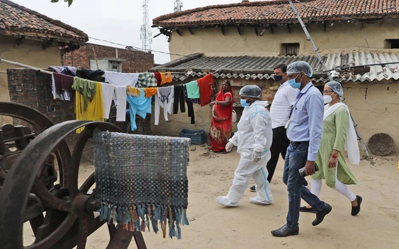 Nhân viên y tế tới làng Sikanderpur, quận Chandauli, bang Uttar Pradesh để lấy mẫu xét nghiệm Covid-19 và vận động người dân tiêm phòng. (Ảnh: AP)