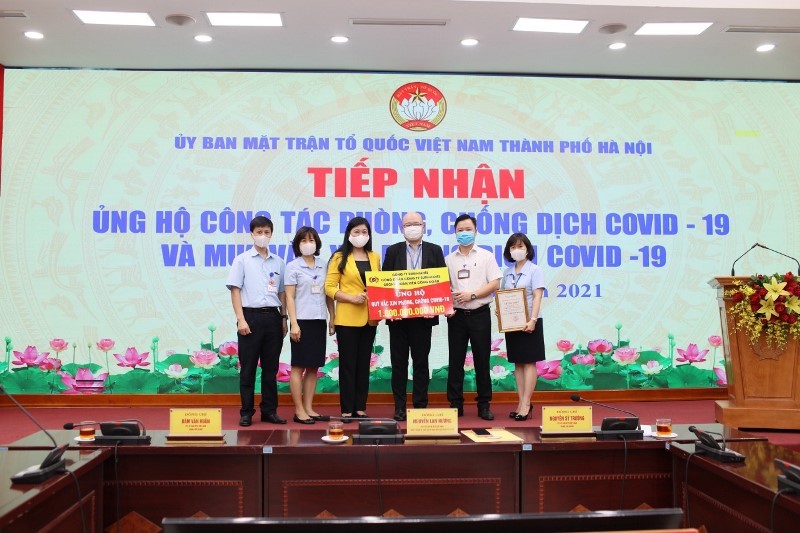 Đại diện Ủy ban Mặt trận Tổ quốc thành phố Hà Nội tiếp nhận kinh phí mua vaccine do các doanh nghiệp ủng hộ.