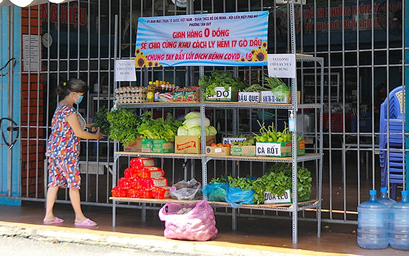 Người dân hẻm 17, đường Gò Dầu (phường Tân Quý, quận Tân Phú, TP Hồ Chí Minh) đi chợ tại "Gian hàng 0 đồng sẻ chia cùng khu cách ly". Ảnh: HUẾ XUÂN