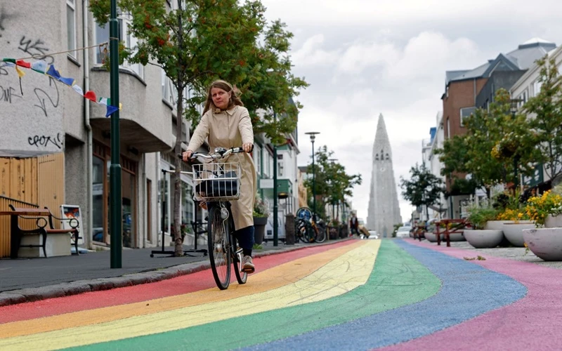 Người phụ nữ đạp xe trên “đường cầu vồng” tại thủ đô Reykjavik của Iceland. (Ảnh: Reuters)
