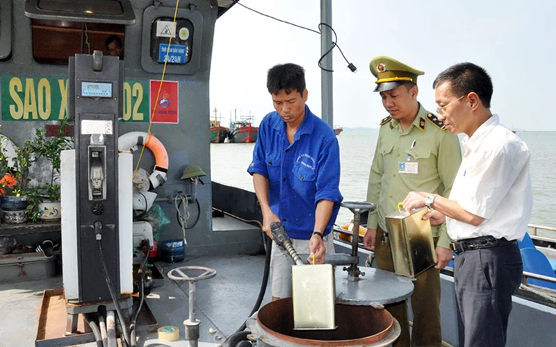 Cục Quản lý thị trường tỉnh Quảng Ninh lấy mẫu kiểm tra xăng, dầu tại Cửa hàng kinh doanh xăng dầu trên biển, TP Móng Cái, của Công ty cổ phần Minh Phú 689. Ảnh: HỮU VIỆT