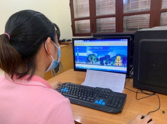 Túc trực hỗ trợ cha mẹ học sinh đăng ký thử nghiệm tuyển sinh trực tuyến tại Trường tiểu học Ba Trại B, huyện Ba Vì. 
