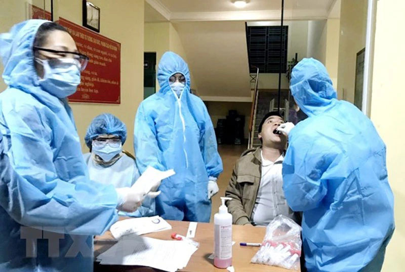 Lực lượng y tế của Trung tâm y tế huyện Vân Đồn triển khai lấy mẫu xét nghiệm cho người dân trên địa bàn. (Ảnh: TTXVN)