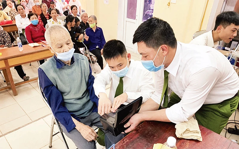 Công an huyện Thanh Trì hỗ trợ người cao tuổi làm căn cước công dân. 