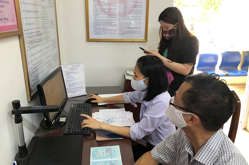 Cán bộ phường Ngọc Lâm (quận Long Biên, Hà Nội) hỗ trợ công dân thực hiện dịch vụ công trực tuyến trên mạng internet. (Ảnh: ĐĂNG ANH)
